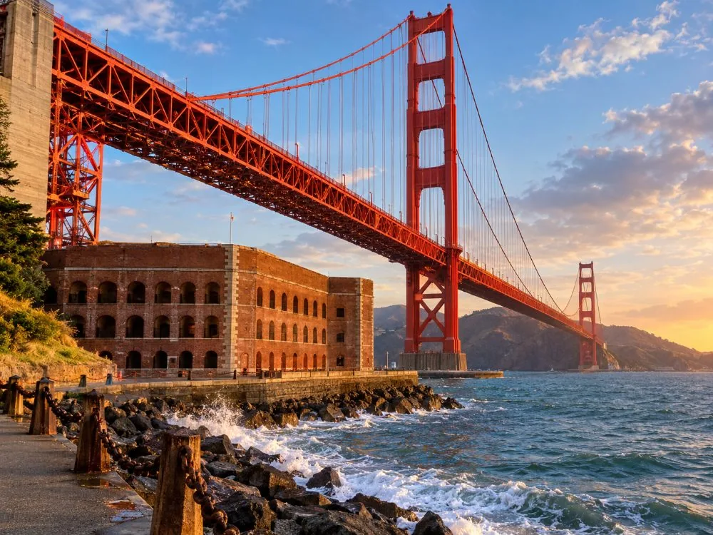 The Golden Gate Bridge arching over the brick walls of Fort Point